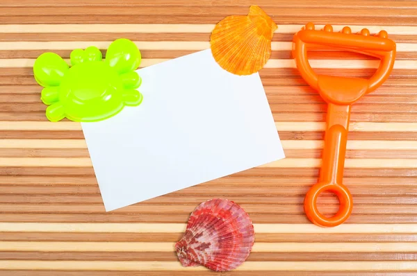 Paper card and seashells toy shovel on wood — Stock Photo, Image