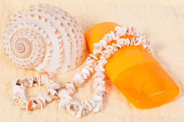 Bottle of shampoo and towel seashells, shell beads — Stock Photo, Image