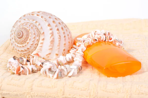 Bottle of shampoo and towel seashells, shell beads — Stock Photo, Image