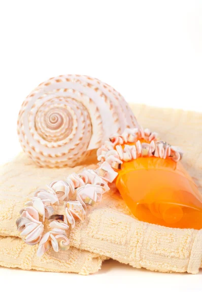 Bottle of shampoo and towel seashells, shell beads — Stock Photo, Image