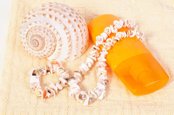Şişe şampuan ve havlu deniz kabuğu, kabuk boncuklar — Stok fotoğraf