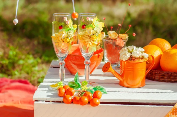 Oranje picnic met sinaasappelen bloemen en glazen — Stockfoto