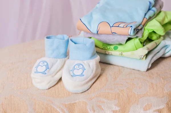 Botín de bebé y ropa doblada — Foto de Stock