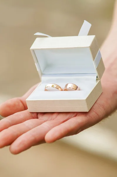 Boîte avec anneaux de mariage dans les mains — Photo