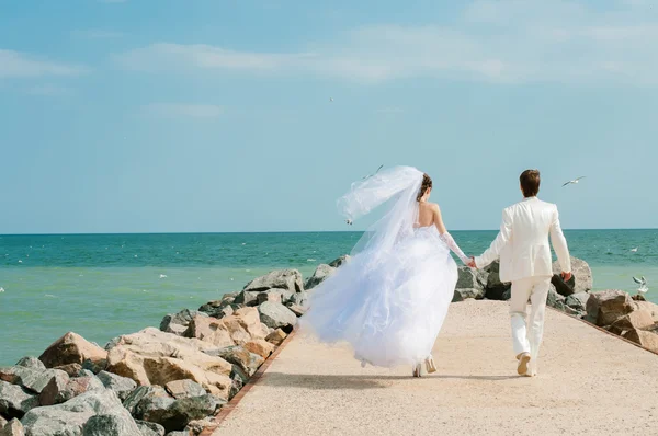 Young and beautiful bride and groom on the beach — Stock Photo, Image