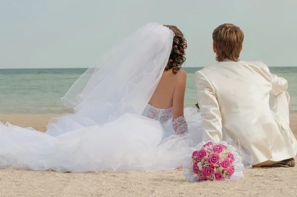 Young and beautiful bride and groom on the beach — Stock Photo, Image