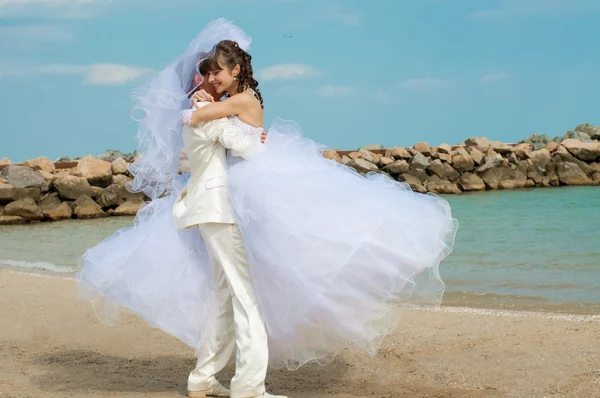 Young and beautiful bride and groom on the beach — Stock Photo, Image