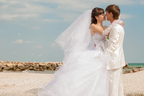 Young and beautiful bride and groom on the beach — Stock Photo, Image