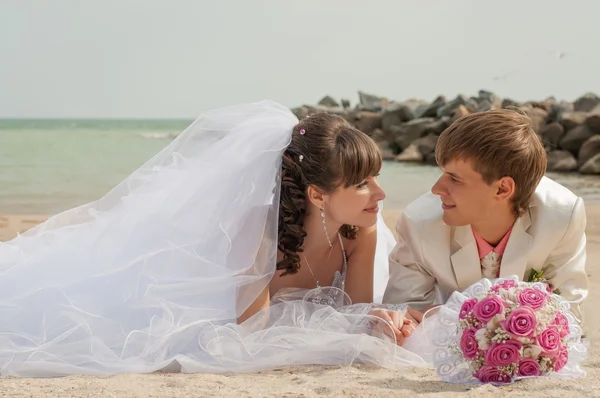 Young and beautiful bride and groom on the beach — Stock Photo, Image