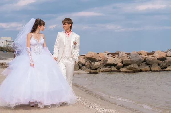 Noiva jovem e bonita e noivo na praia — Fotografia de Stock