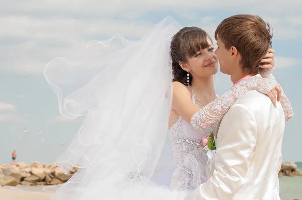 Young and beautiful bride and groom on the beach — Stock Photo, Image