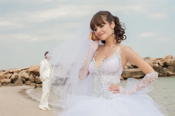 Giovane bella sposa sulla spiaggia con conchiglia — Foto Stock