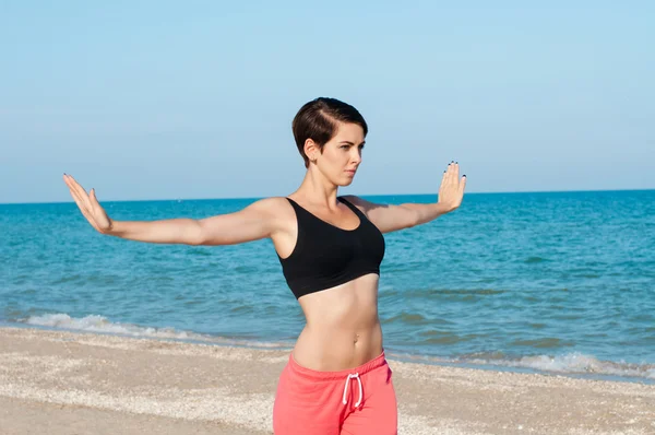 Young beautiful girl athlete playing sports on the beach — Stock Photo, Image