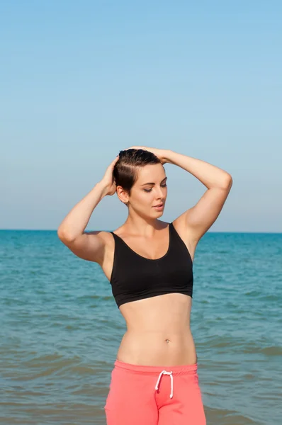 Junge schöne Sportlerin beim Sport am Strand — Stockfoto