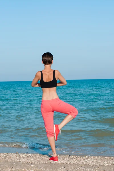 Genç güzel kız sahilde oynarken spor atlet — Stok fotoğraf