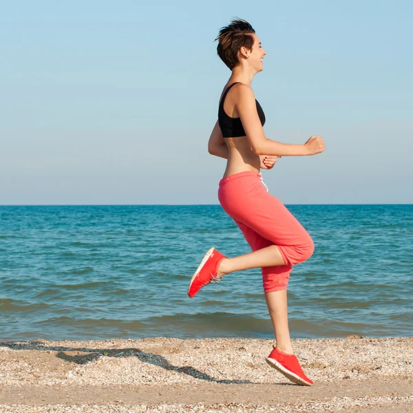 Young beautiful girl athlete playing sports on the beach — Stock Photo, Image