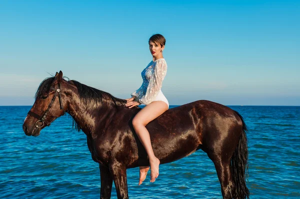 Genç güzel kız sahilde bir atı ile — Stok fotoğraf