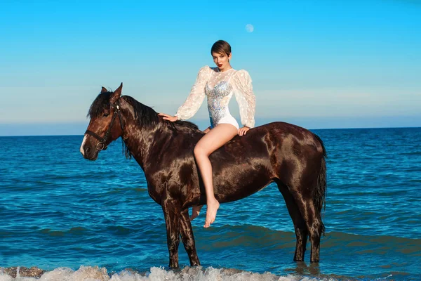 Jeune belle fille avec un cheval sur la plage — Photo