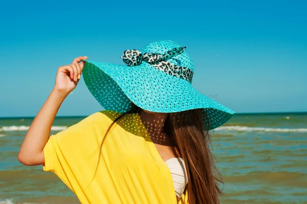 파란 모자에 있는 해변에 긴 머리를 가진 아름 다운 소녀 — 스톡 사진