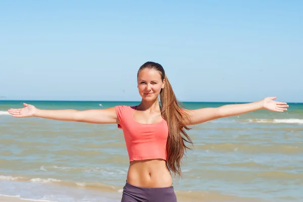 Vacker flicka ägnar sig åt yoga på stranden — Stockfoto