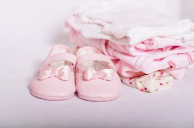 küçük pembe bebek ayakkabıları ve giysileri