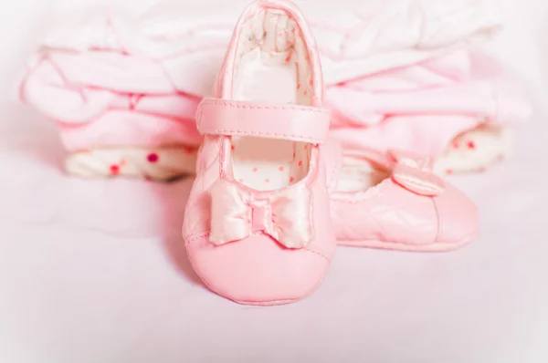 Küçük pembe bebek ayakkabıları ve giysileri — Stok fotoğraf