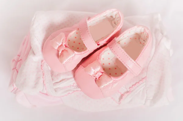 Kleine roze baby schoenen en kleding — Stockfoto