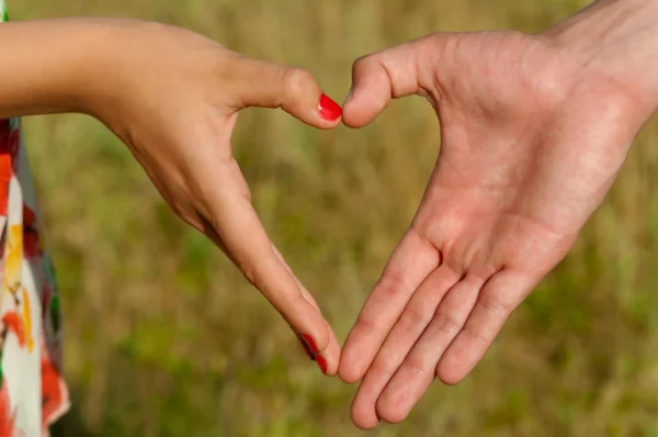 Τα χέρια διπλωμένα ζευγάρι σχήμα καρδιάς — Φωτογραφία Αρχείου