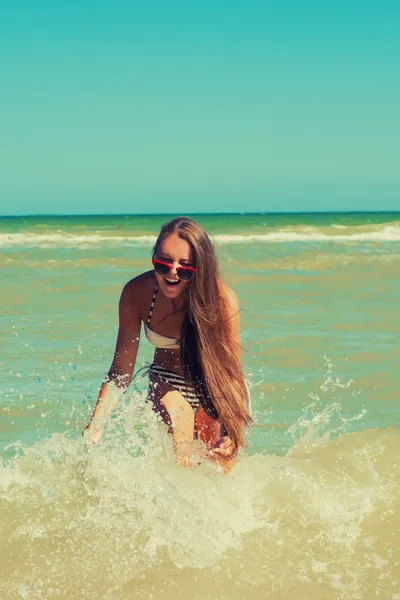 Chica joven en el agua de mar salpica y sonríe —  Fotos de Stock