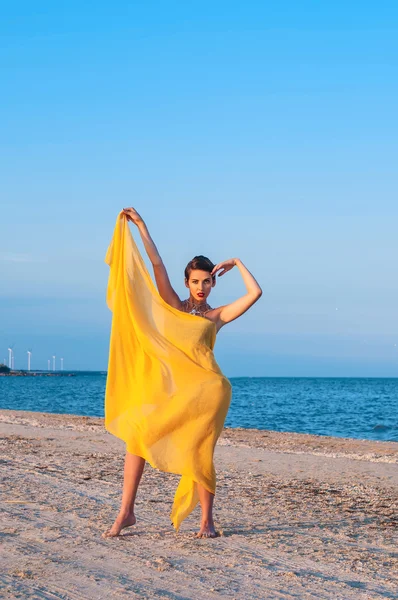Jovem na praia pareo amarelo — Fotografia de Stock