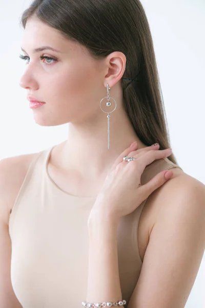 Uzun siyah saçlı güzel bir kıza gümüş mücevherler takılmış. Güzellik ve moda 