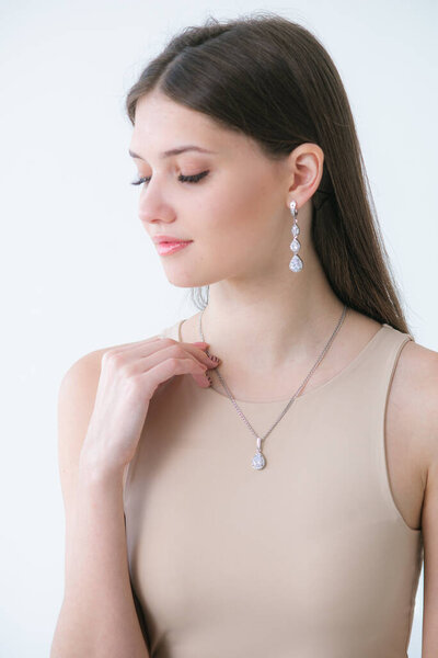 Trending silver jewelry set on a beautiful young girl with long dark hair. Beauty and fashion 
