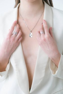 Modaya uygun bir ceketi olan genç ve güzel bir kızın üzerinde inci bulunan gümüş mücevherler. Güzellik ve moda 