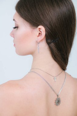 Güzel bir genç kıza gümüş haçlar ve zincirler takmak. Güzellik ve moda 
