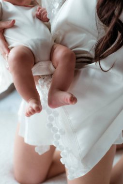 The hands of mom  are holding tiny cute baby feet. Happy motherhood. Healthy lifestyle 