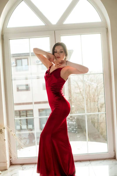 Atrakcyjna Młoda Dziewczyna Ciemnymi Włosami Makijażem Wieczorowym Długiej Czerwonej Sukni — Zdjęcie stockowe