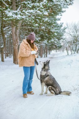 Genç tatlı kız kışın karlı havada parkta eğlenir. Yaşam tarzı 