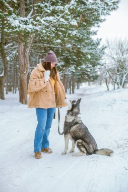 Genç tatlı kız kışın karlı havada parkta eğlenir. Yaşam tarzı 