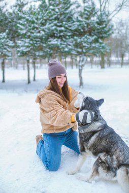 Genç tatlı kız kışın karlı havada parkta eğlenir. Yaşam tarzı 
