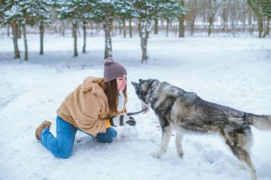Genç tatlı kız kışın karlı havada parkta eğlenir. Yaşam tarzı 