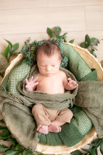 Leuke Kleine Baby Een Rieten Mandje Versierd Met Groene Takken — Stockfoto