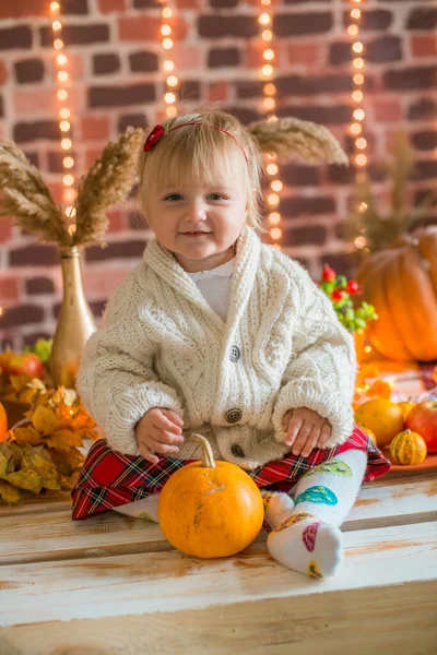 小女孩穿着白色温暖的针织毛衣 内饰有毛毯和枕头 还有南瓜 秋天的叶子和苹果 秋天的心情Hallobetween — 图库照片