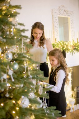 Sarışın, kıvırcık saçlı, klasik kıyafetlerle, klasik iç mekan hediyeleriyle Noel ağacının yanındaki gişeye yasaklı güzel kız kardeşler. Noel havası 