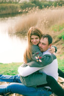 Bir çift uzun boylu genç adam ve uzun sarı saçlı kız arkadaşı nehir kıyısında şehrin dışında yürüyorlar. Duygular ve duygular. Yaşam tarzı. Ülke havası