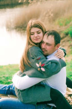 Bir çift uzun boylu genç adam ve uzun sarı saçlı kız arkadaşı nehir kıyısında şehrin dışında yürüyorlar. Duygular ve duygular. Yaşam tarzı. Ülke havası