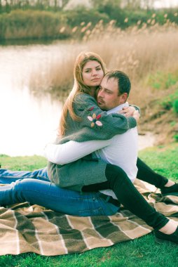 Bir çift uzun boylu genç adam ve uzun sarı saçlı kız arkadaşı nehir kıyısında şehrin dışında yürüyorlar. Duygular ve duygular. Yaşam tarzı. Ülke havası