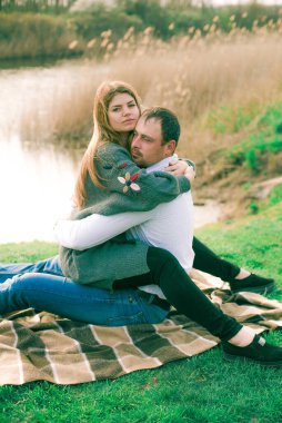 Bir çift uzun boylu genç adam ve uzun sarı saçlı kız arkadaşı nehir kıyısında şehrin dışında yürüyorlar. Duygular ve duygular. Yaşam tarzı. Ülke havası