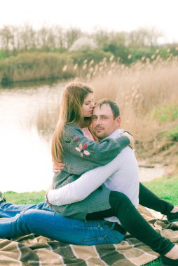 Bir çift uzun boylu genç adam ve uzun sarı saçlı kız arkadaşı nehir kıyısında şehrin dışında yürüyorlar. Duygular ve duygular. Yaşam tarzı. Ülke havası