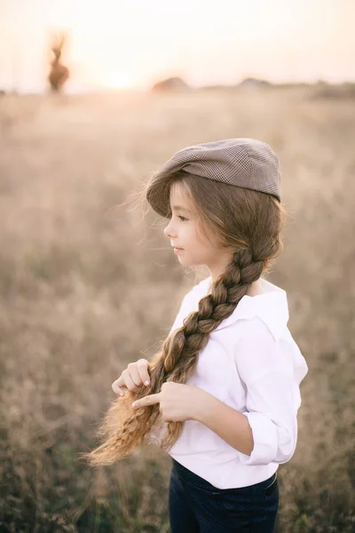 在夏日的田野里 一个漂亮的小女孩 金发碧眼 身穿白衬衫 头戴一顶男士的老式礼帽 — 图库照片