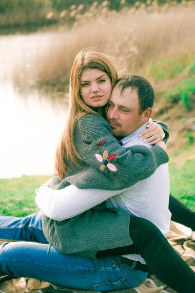 Bir çift uzun boylu genç adam ve uzun sarı saçlı kız arkadaşı nehir kıyısında şehrin dışında yürüyorlar. Duygular ve duygular. Yaşam tarzı. Ülke havası